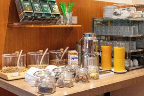 A breakfast buffet with various food items, a coffee machine, and a juice dispenser. - Hotel Montana Diemelstadt (Diemelstadt)