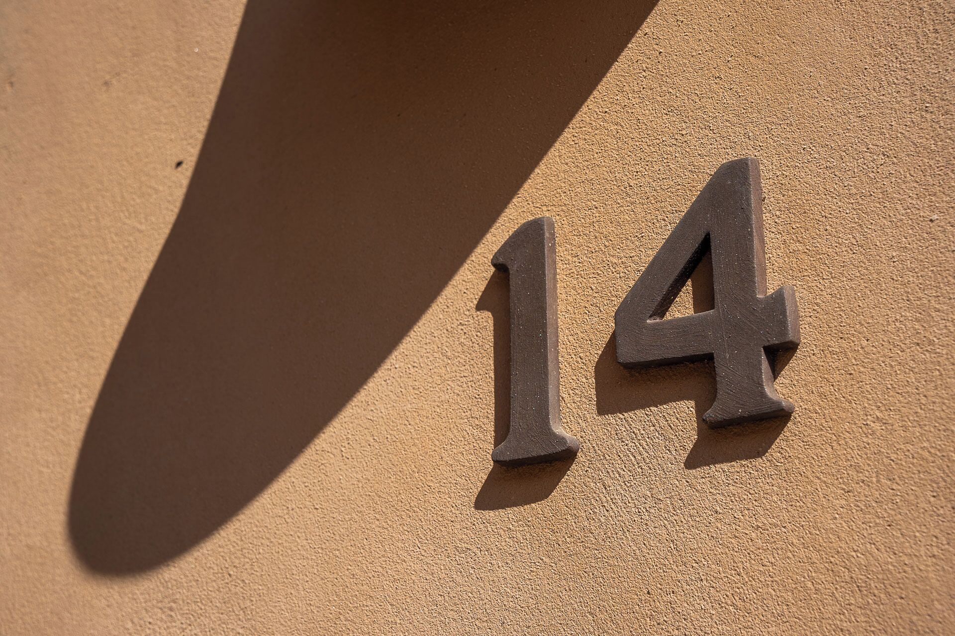 A house number '14' on a textured wall.