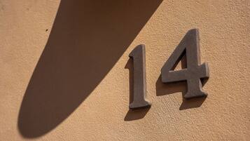 A house number '14' on a textured wall.