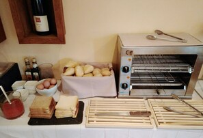 Una cocina con horno tostador, pan, huevos y una botella de vino.