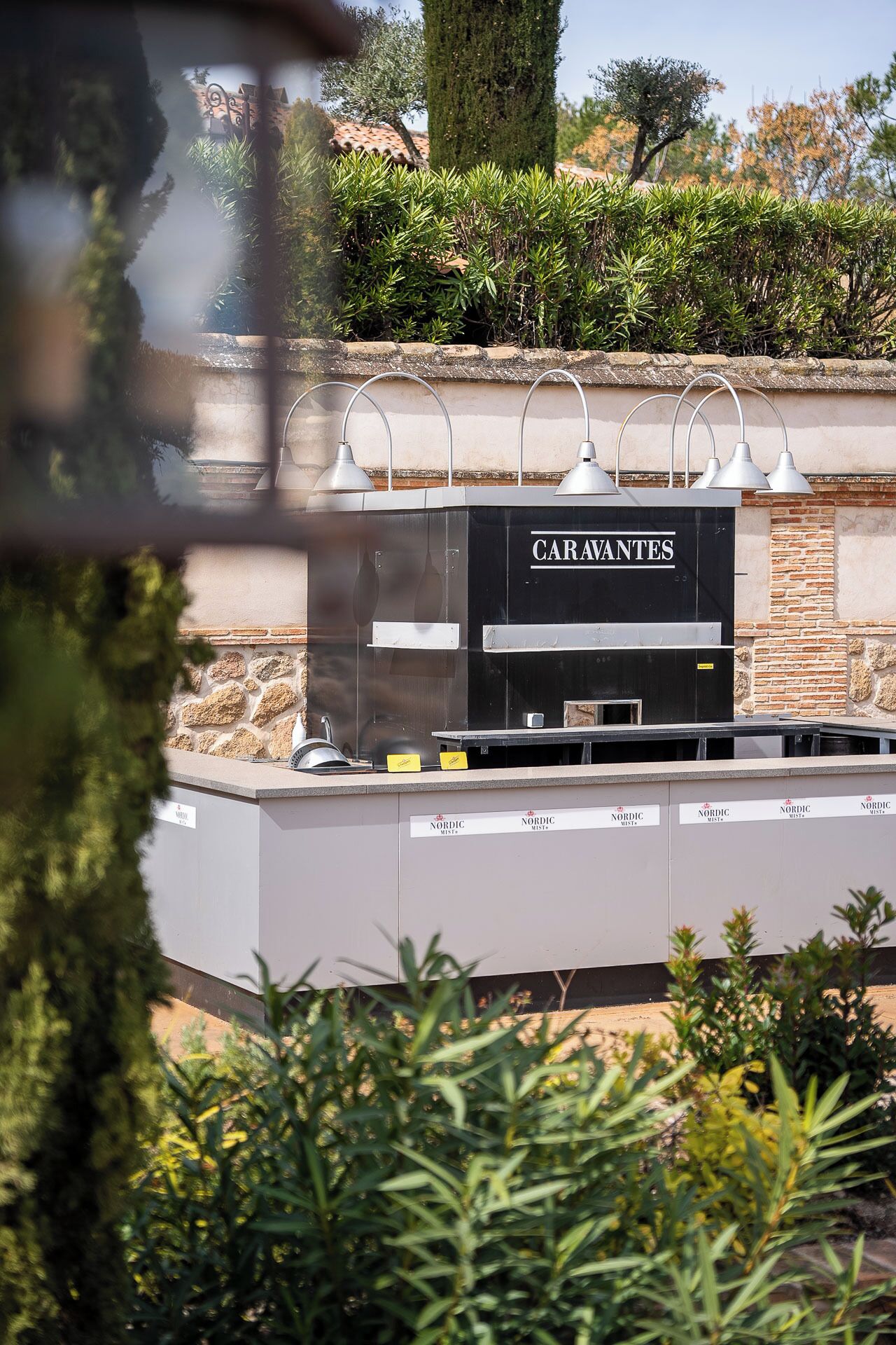 A restaurant named "CARAVANTES" with outdoor seating and a stone wall backdrop.
