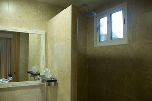 A bathroom with a large mirror, a shower, and a window. - Hotel MR (Tarragona)