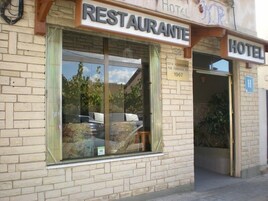 Un edificio con un'insegna 'RESTAURANTE' e un'insegna 'HOTEL', che indica la presenza di un ristorante e un albergo.