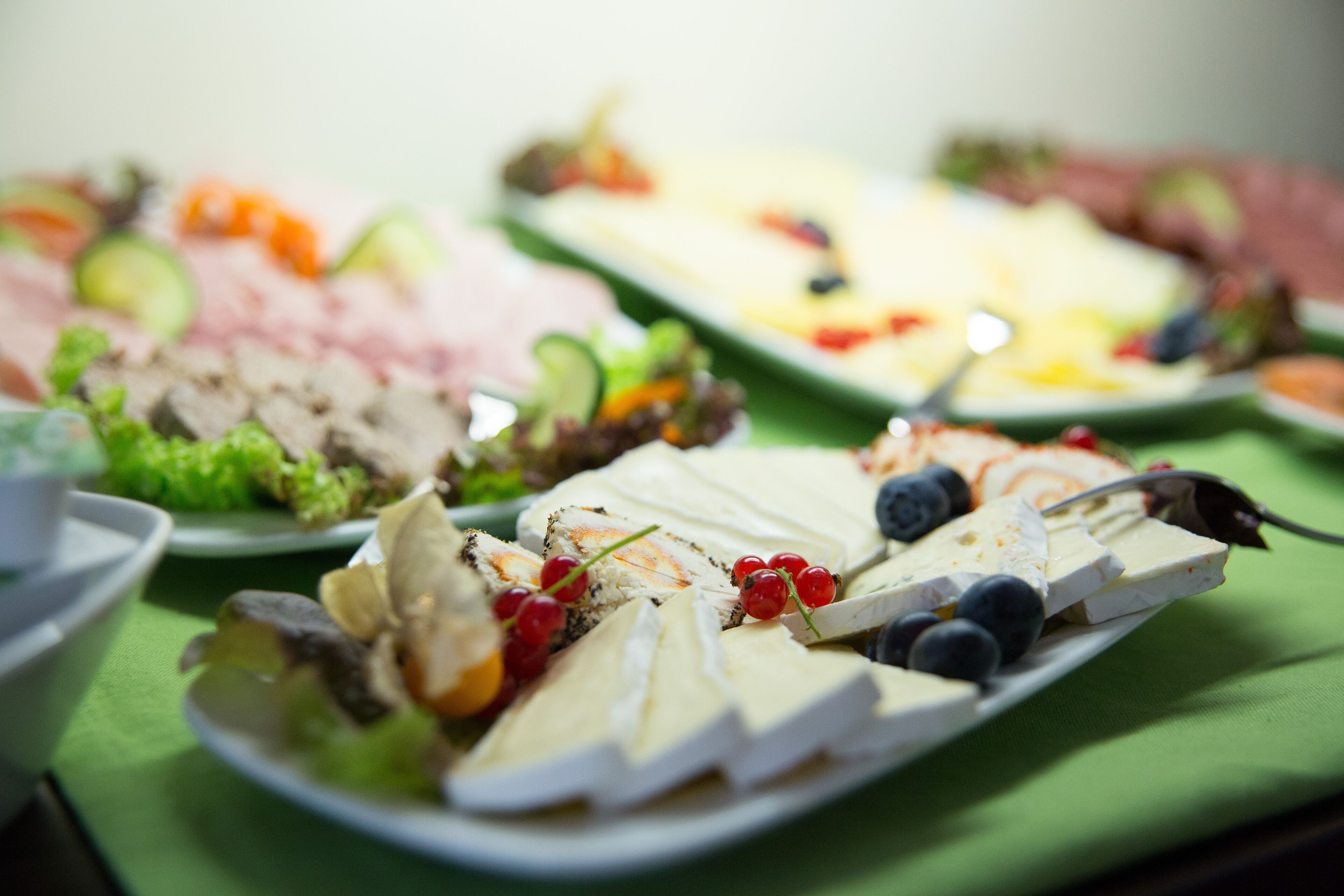 Ein reichhaltiges Buffet mit Käse, Obst und Gemüse.
