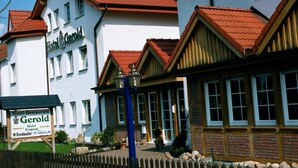 A hotel with a traditional European architectural style, featuring a red-tiled roof and white walls. - Hotel Restaurant Gerold (Paderborn)