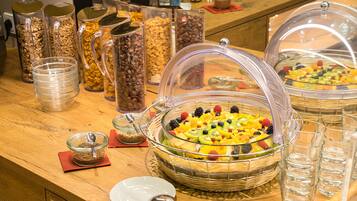 Buffet com diversos recipientes de comida e uma saladeira.