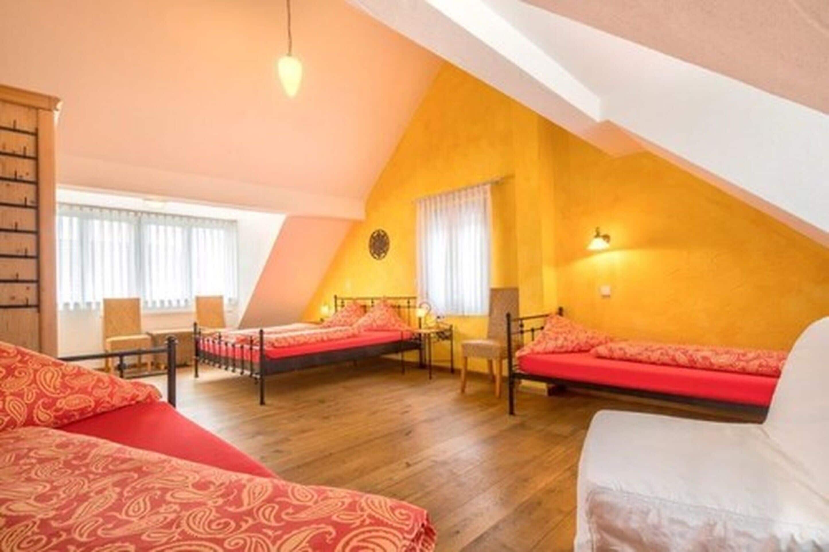 Une chambre avec deux lits, une armoire en bois et une fenêtre avec des rideaux.