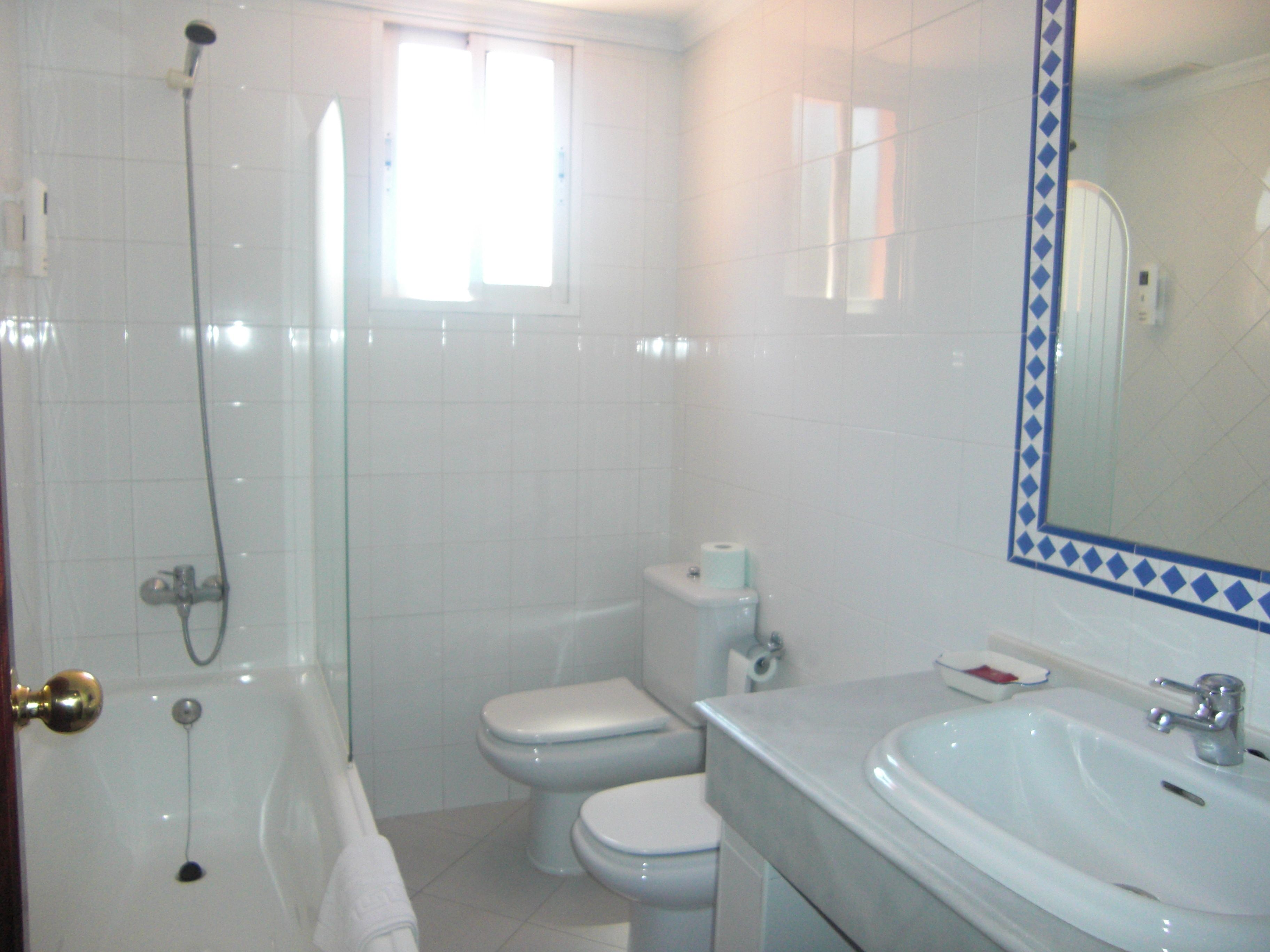 Un baño con bañera, inodoro y lavamanos.