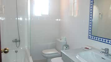 A bathroom with a bathtub, toilet, and sink.