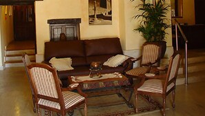 A cozy living room with a brown sofa, striped chairs, a coffee table, and a hanging lantern. - Nuevo Arlanza (Covarrubias)
