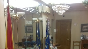 A reception area with a check-in counter, seating area, and a chandelier. - Hostal Cruz Sol (Madrid)