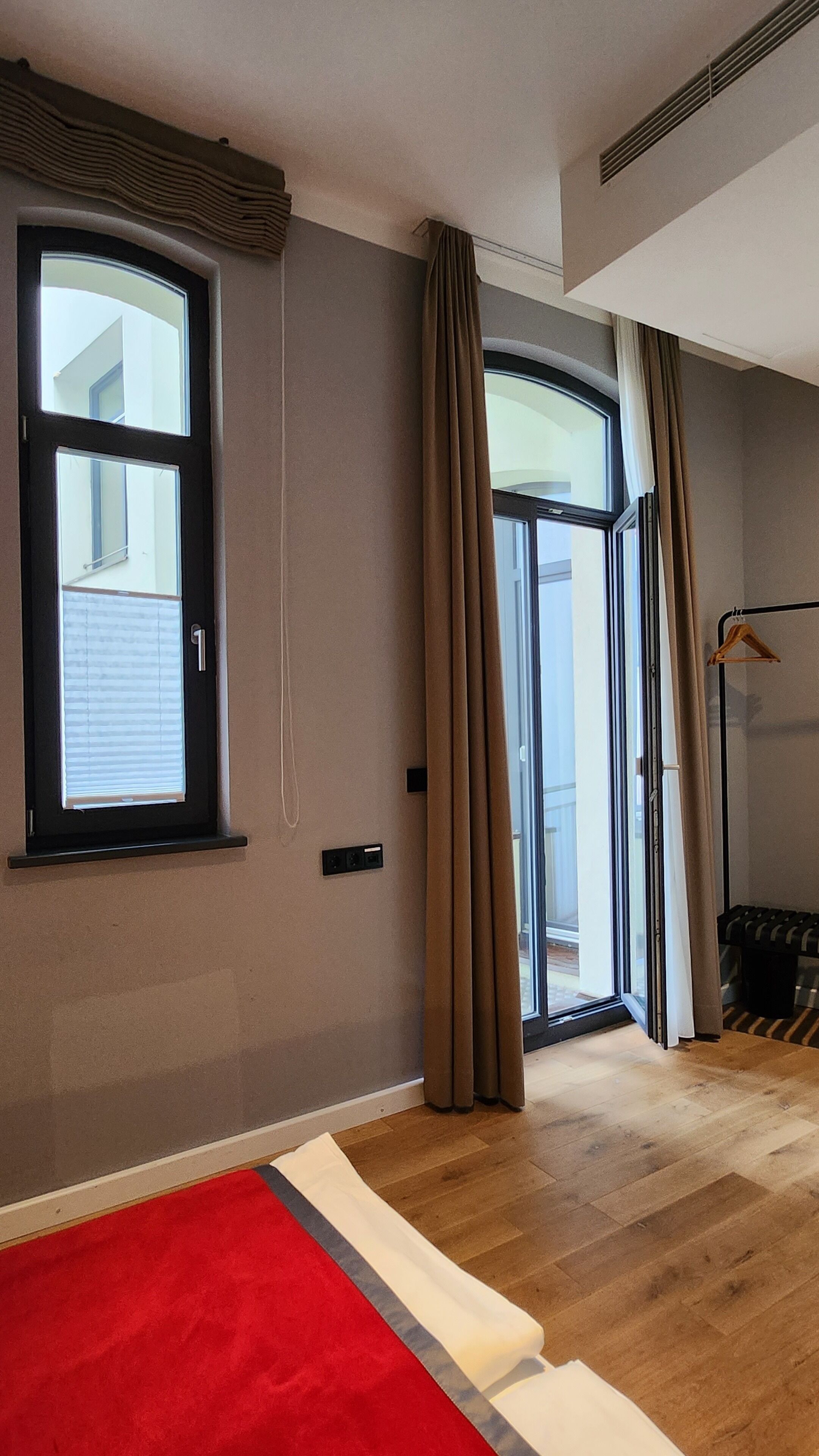 Una habitación con un ventanal grande, una puerta corrediza de vidrio y una alfombra roja.