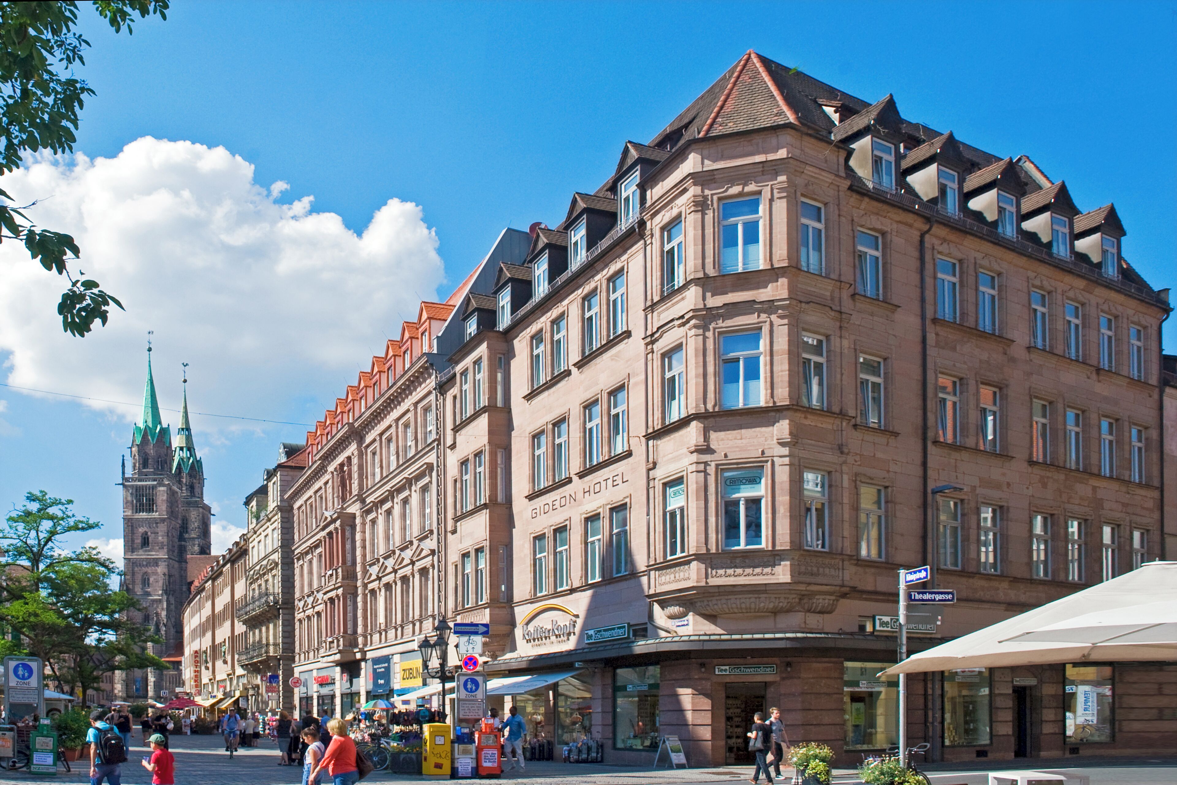 A historic building with a prominent Giedeon Hotel sign, large windows, and a traditional European architectural style.