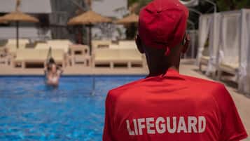 Een seizoensgebonden buitenzwembad, ligstoelen bij het zwembad