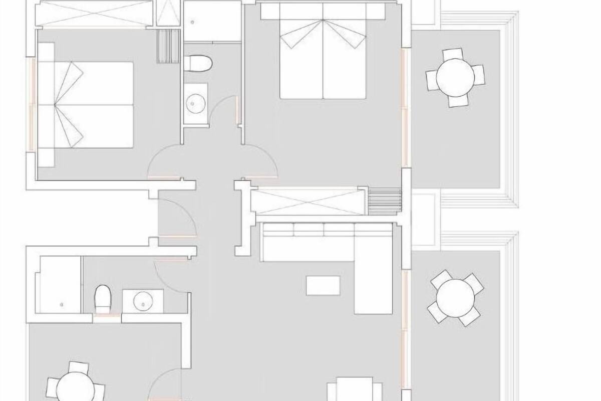 A floor plan of a hotel with a central living area, two bedrooms, a bathroom, and a dining area.