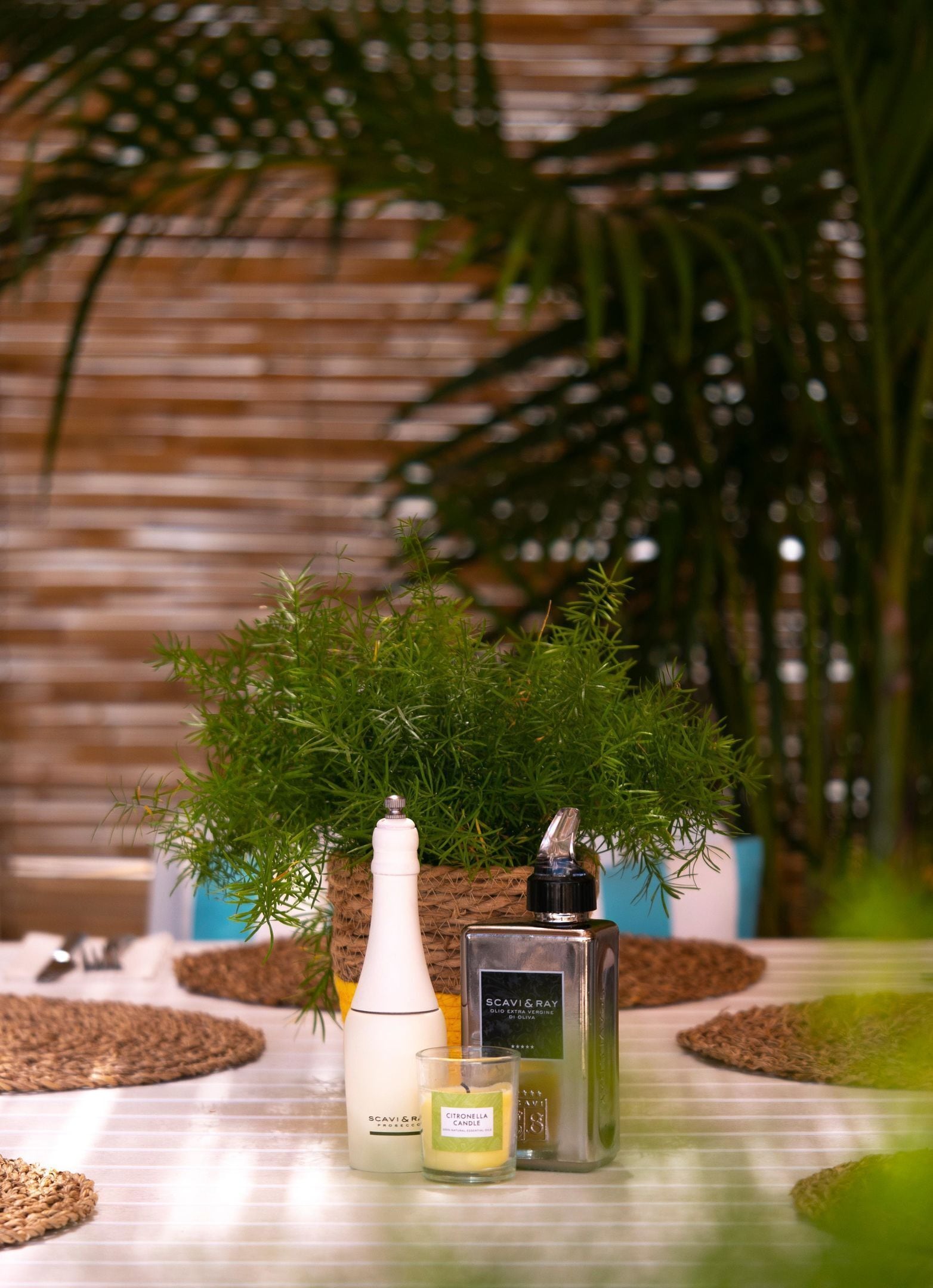 Een tafel met een fles, een glas en een doos kaarsen.