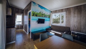 A compact living space with a kitchenette, a dining area, a sofa, and a TV mounted on the wall. -  Alannia Costa Blanca Resort (Crevillente)