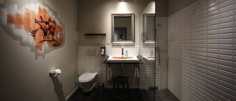 Un baño moderno con inodoro, lavamanos y ducha.