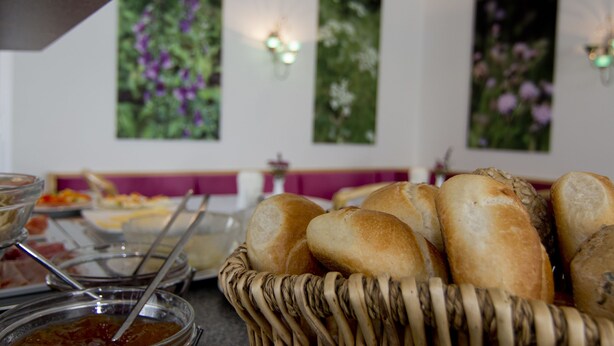 A buffet setup with bread and various dishes. - Hotel Alpha (Nuremberg)