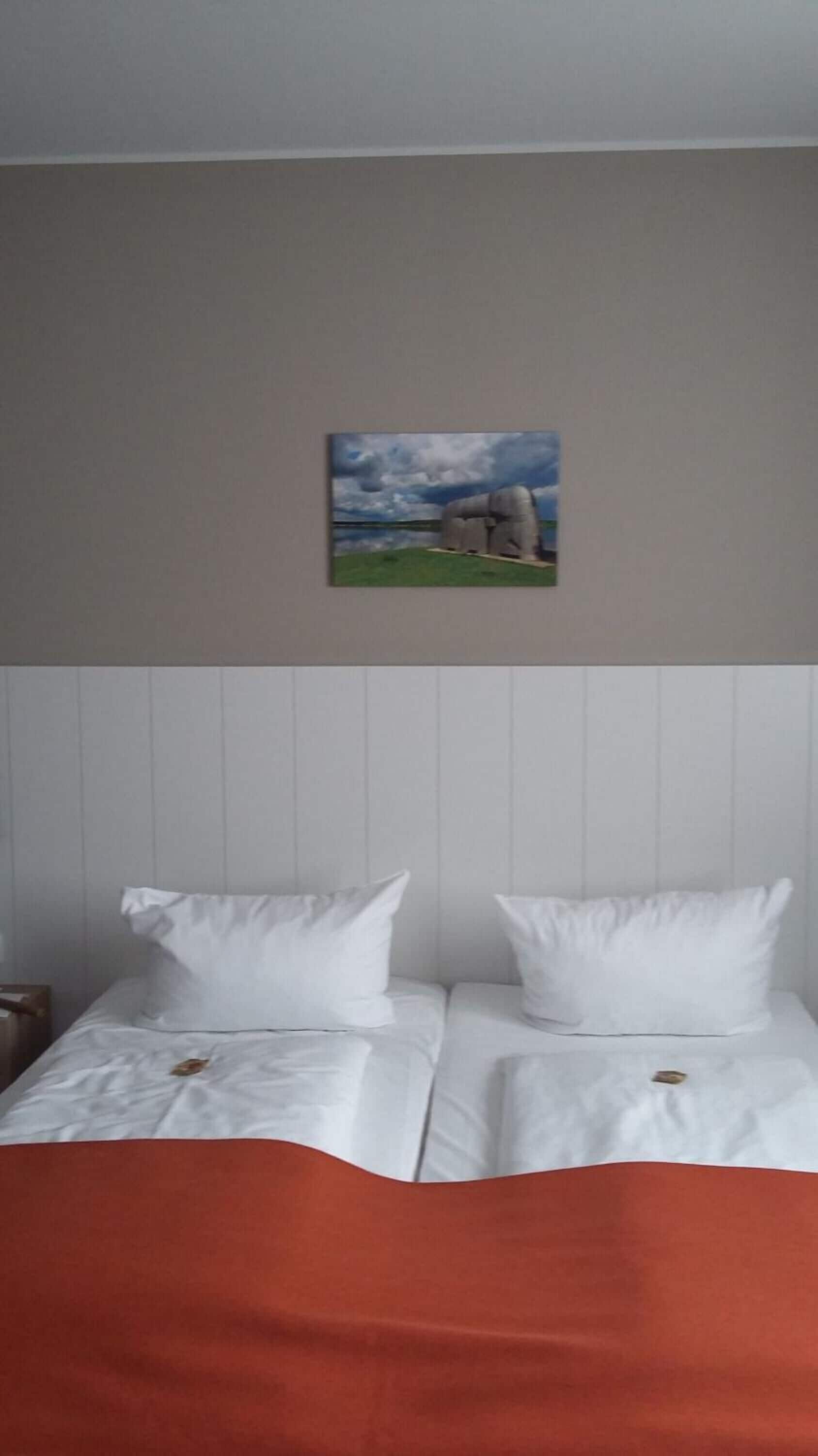 Ein Hotelzimmer mit zwei Betten, einem Landschaftsbild und Meerblick.