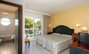 A bedroom with a bed, a television, and a balcony with chairs. - Es Pi2 (Formentera)