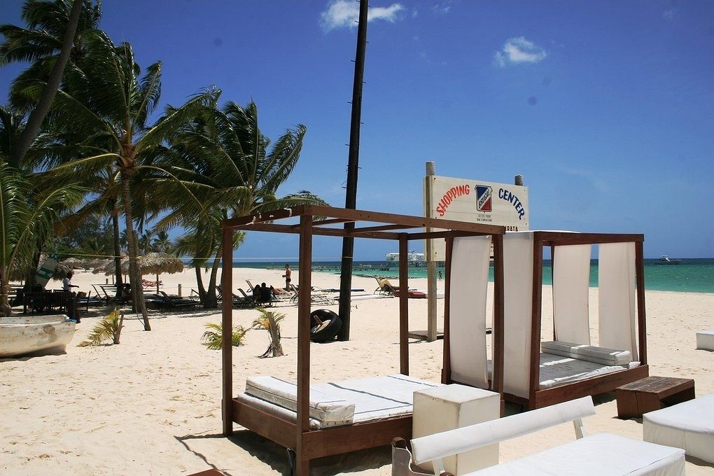 A beachside hotel with a sign indicating a shopping center nearby.