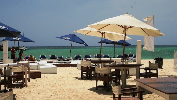 A beachside restaurant with outdoor seating, including tables and chairs, and umbrellas. - Bavaro Green (Punta Cana)
