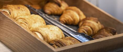 A wooden box containing several croissants.