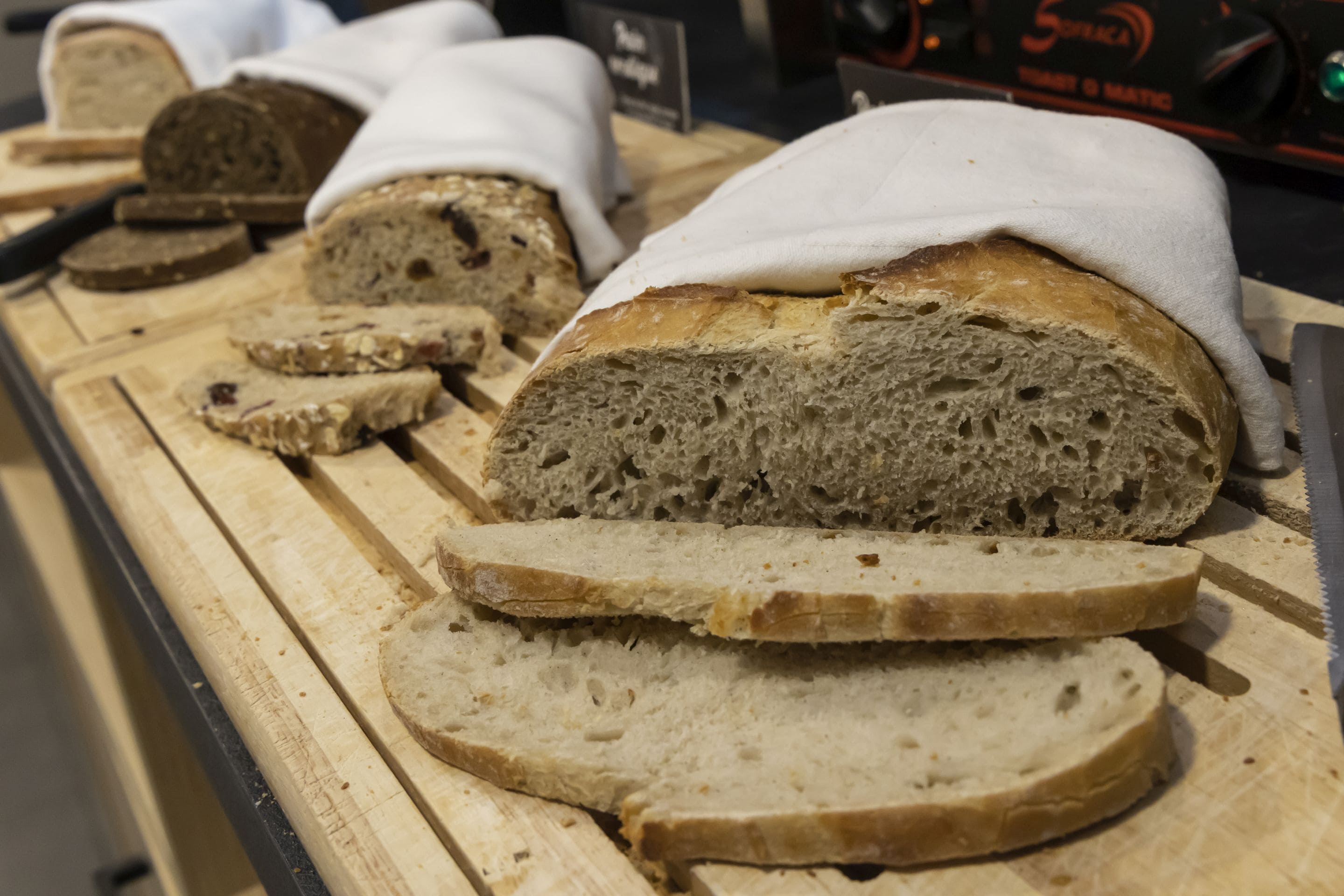 A display of sliced bread on a wooden cutting board.