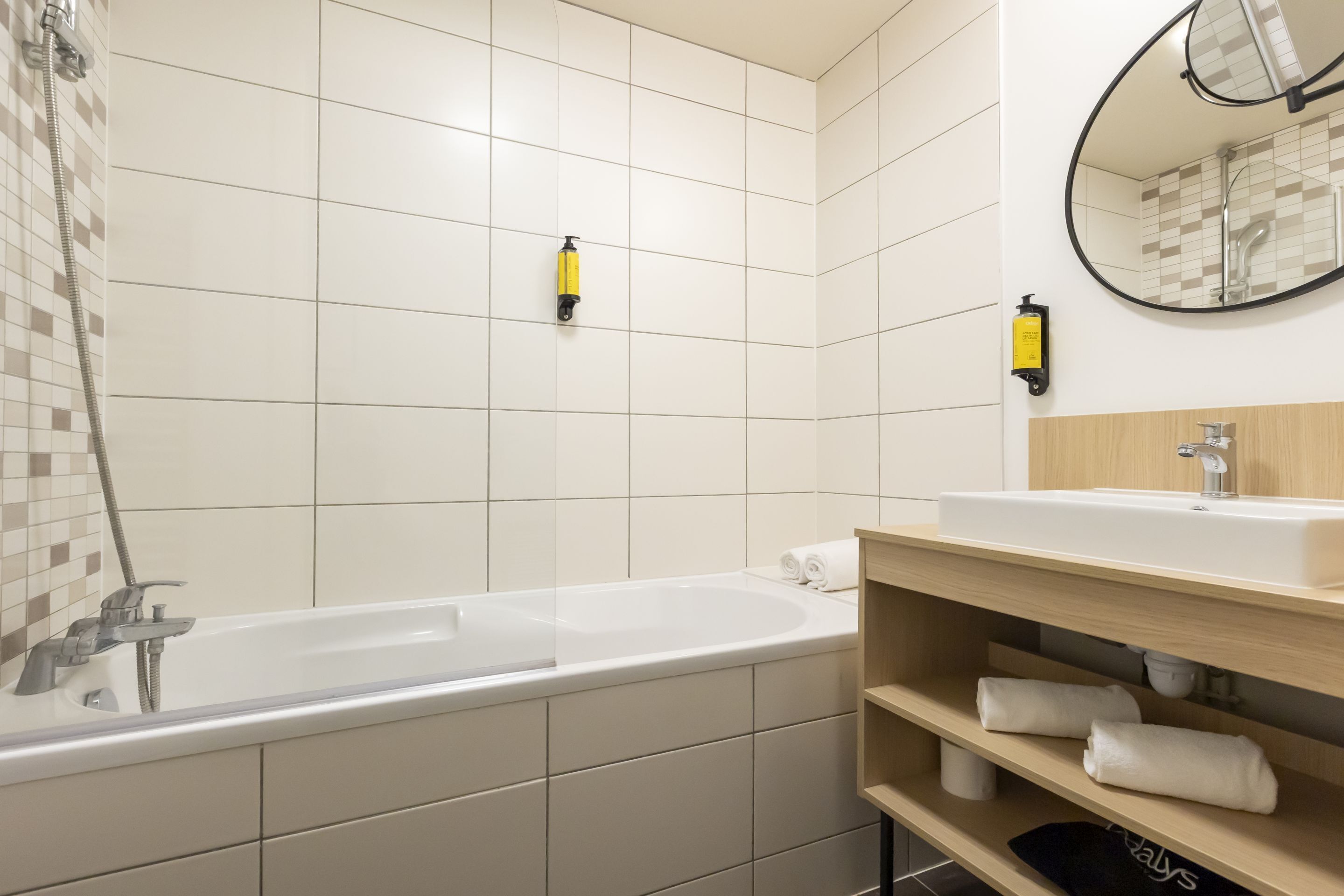 A modern bathroom with a bathtub, a sink, and a mirror.