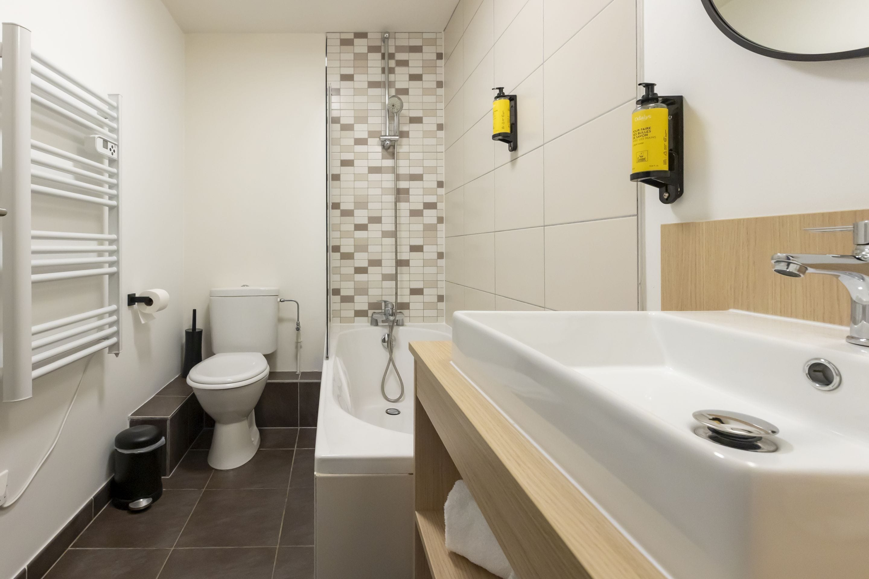 A modern bathroom with a toilet, bathtub, and sink.