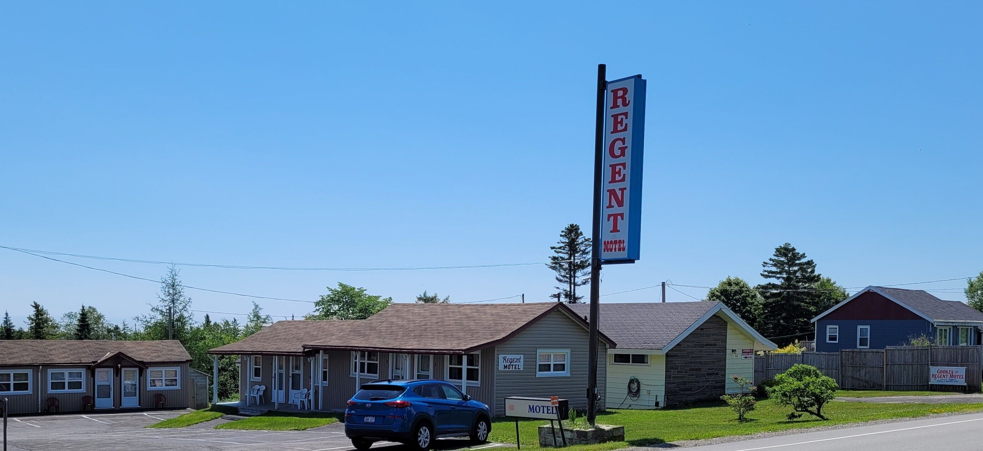 Ein Motel mit auffälligem Schild, einem Parkplatz und mehreren Gebäuden im Hintergrund.