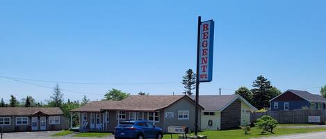 Ein Motel mit auffälligem Schild, einem Parkplatz und mehreren Gebäuden im Hintergrund.