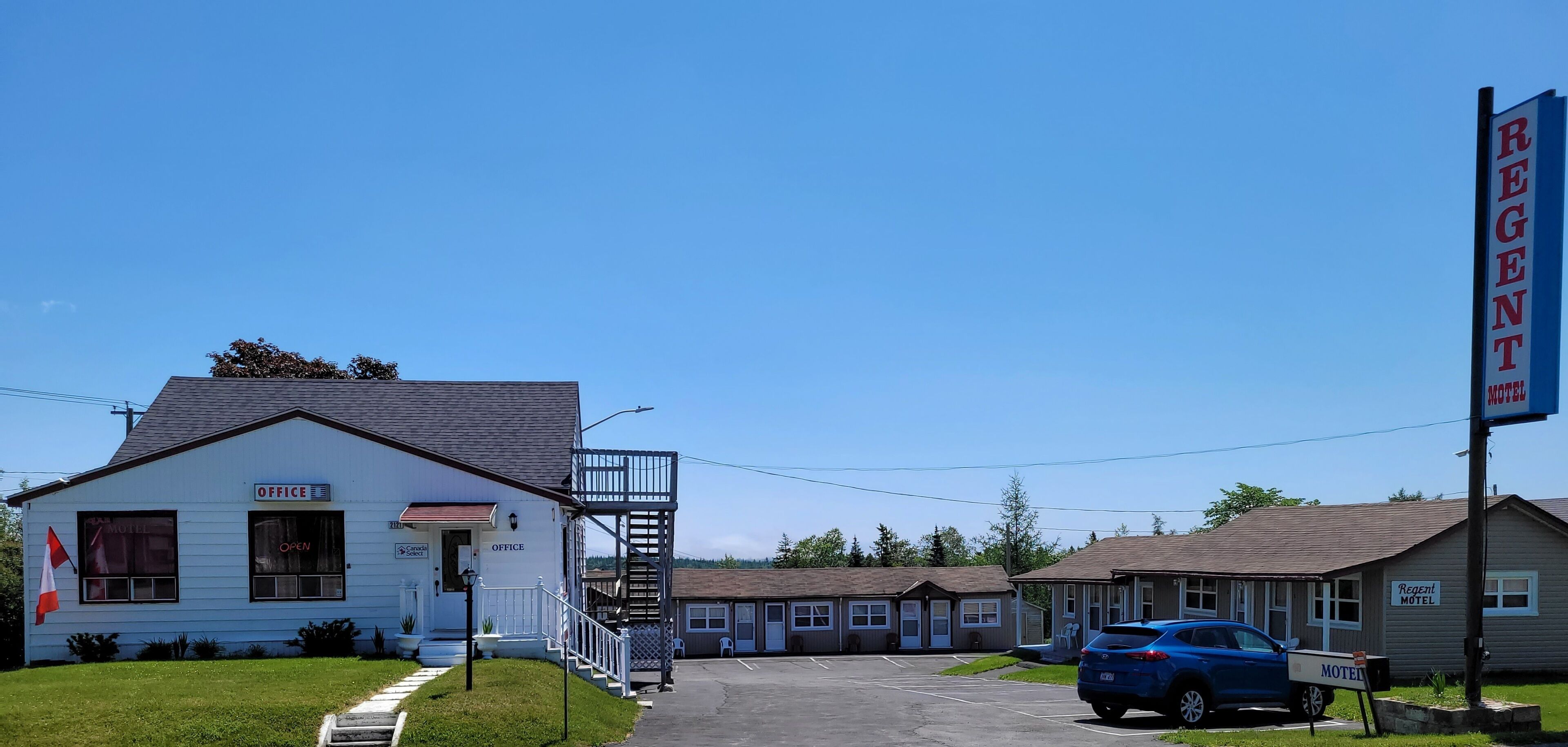 Un motel con un edificio blanco en el que se lee "OFICINA" y un letrero que dice "REGENT MOTEL".