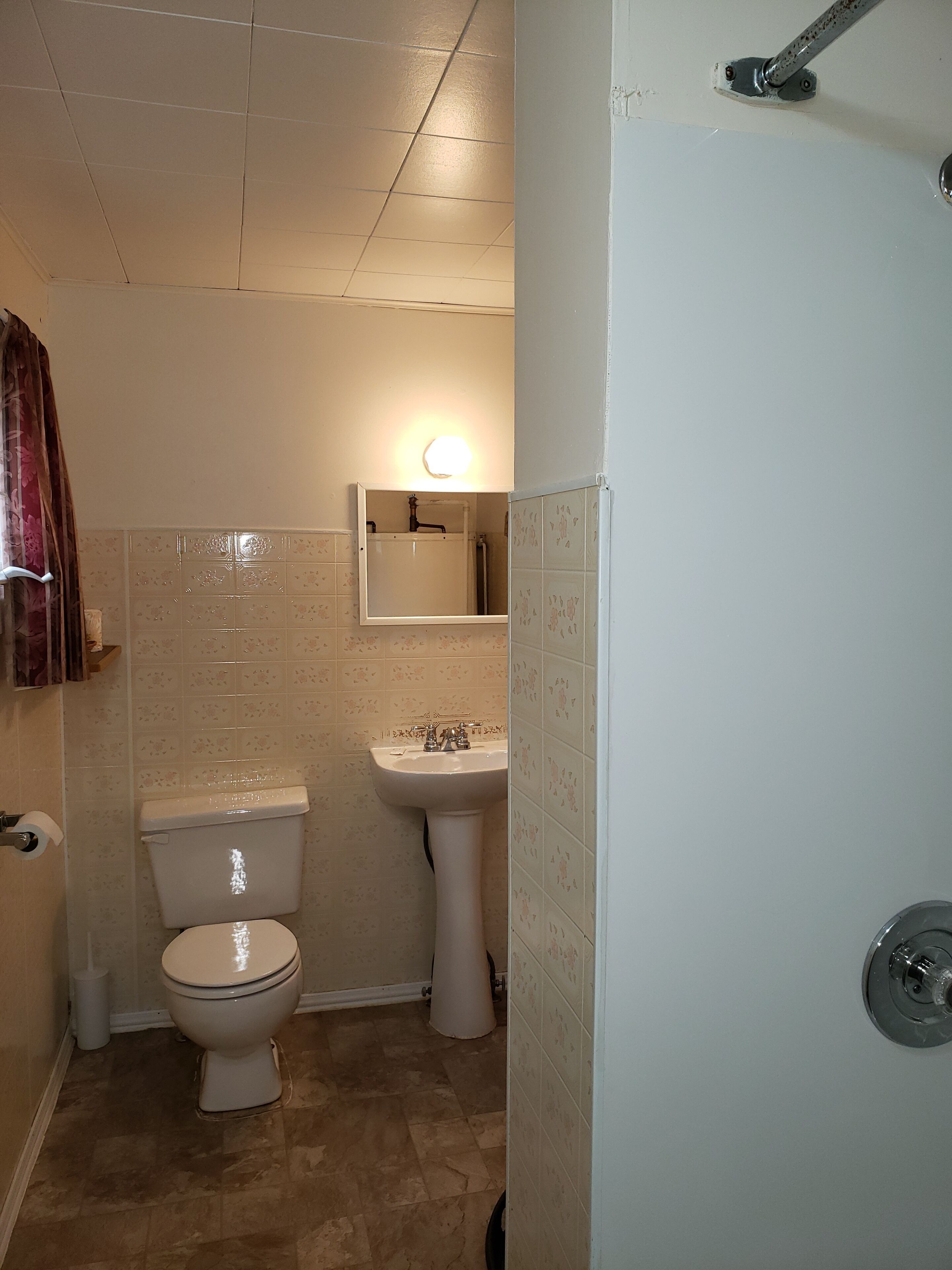 Un baño con inodoro, lavamanos y ducha.