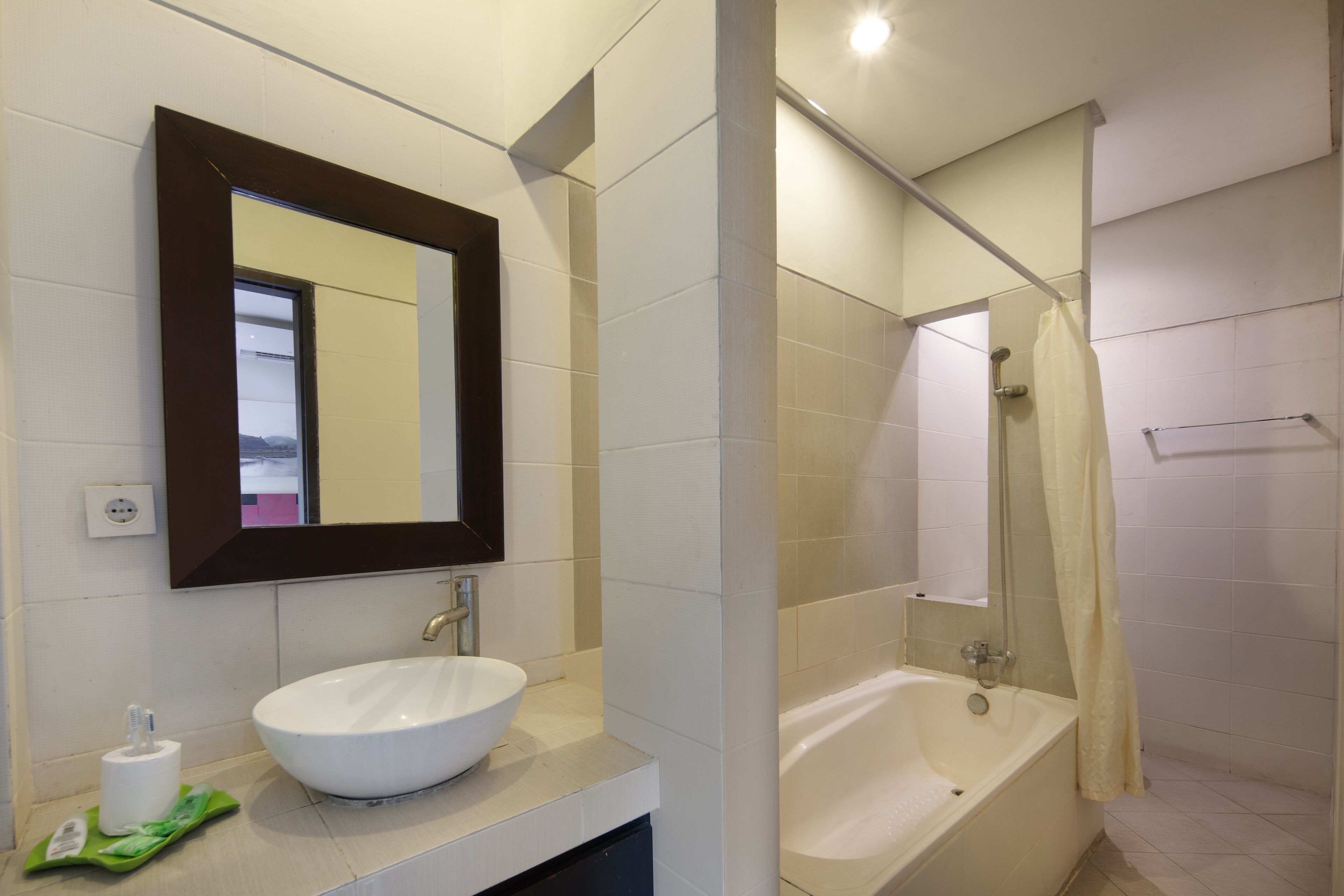 A modern bathroom with a white sink, a large mirror, and a bathtub.