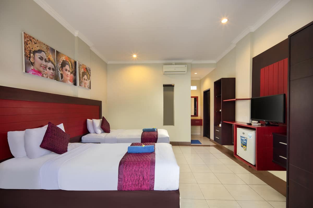 A hotel room with two beds, a TV, a minibar, and a red wardrobe.