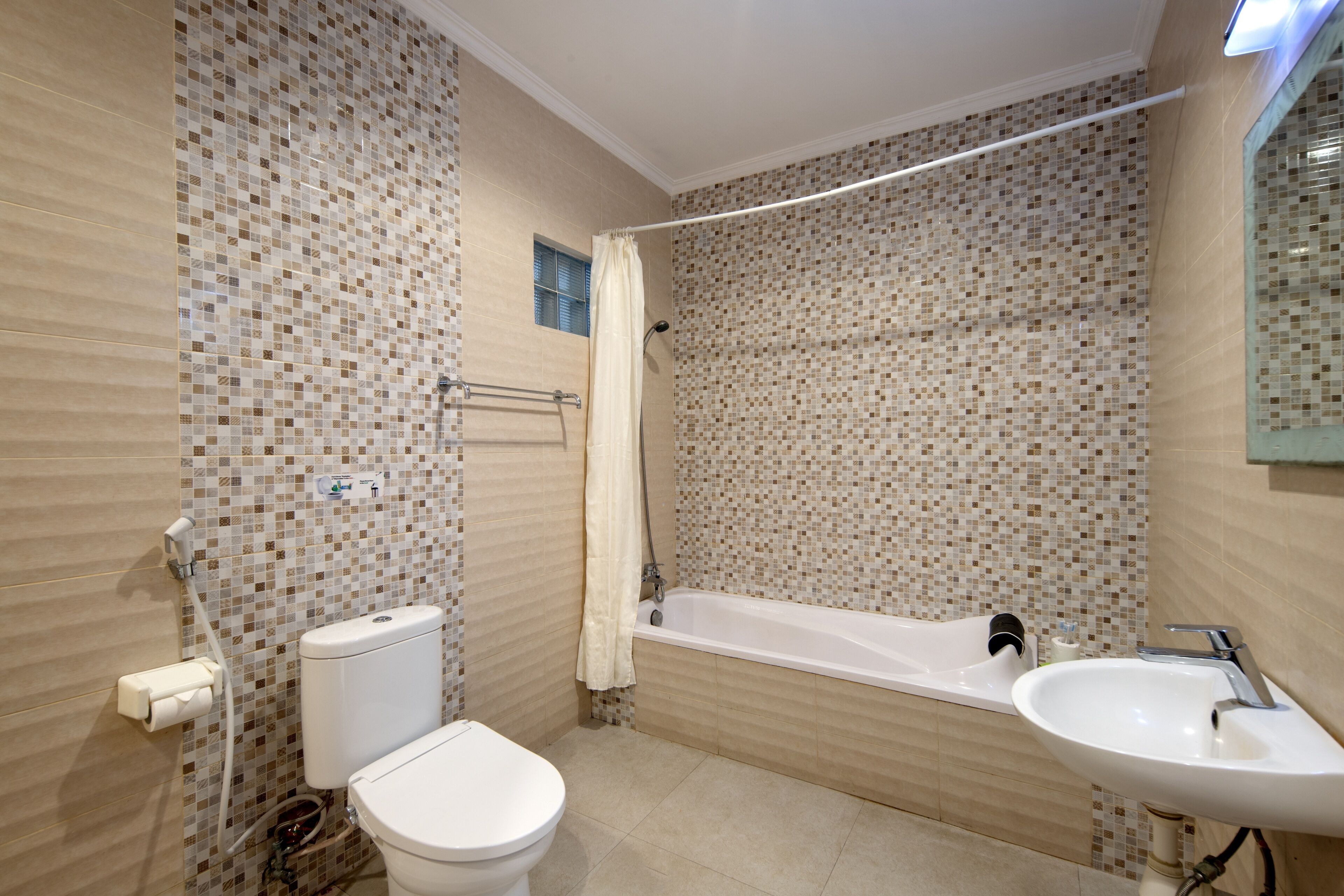 A bathroom with a toilet, bathtub, and sink.