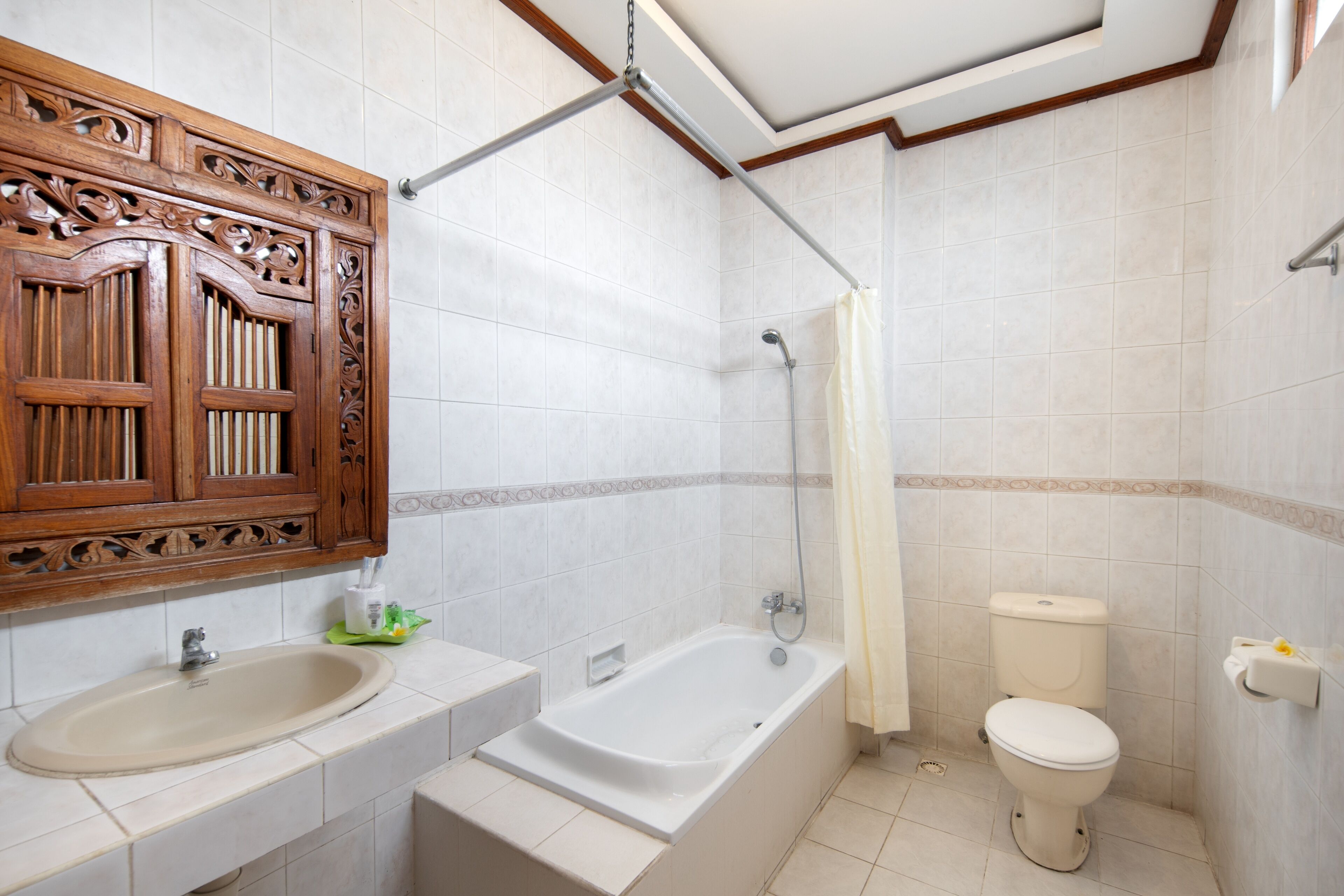 Ein Badezimmer mit Holzwaschtisch, Badewanne, Toilette und Dusche.