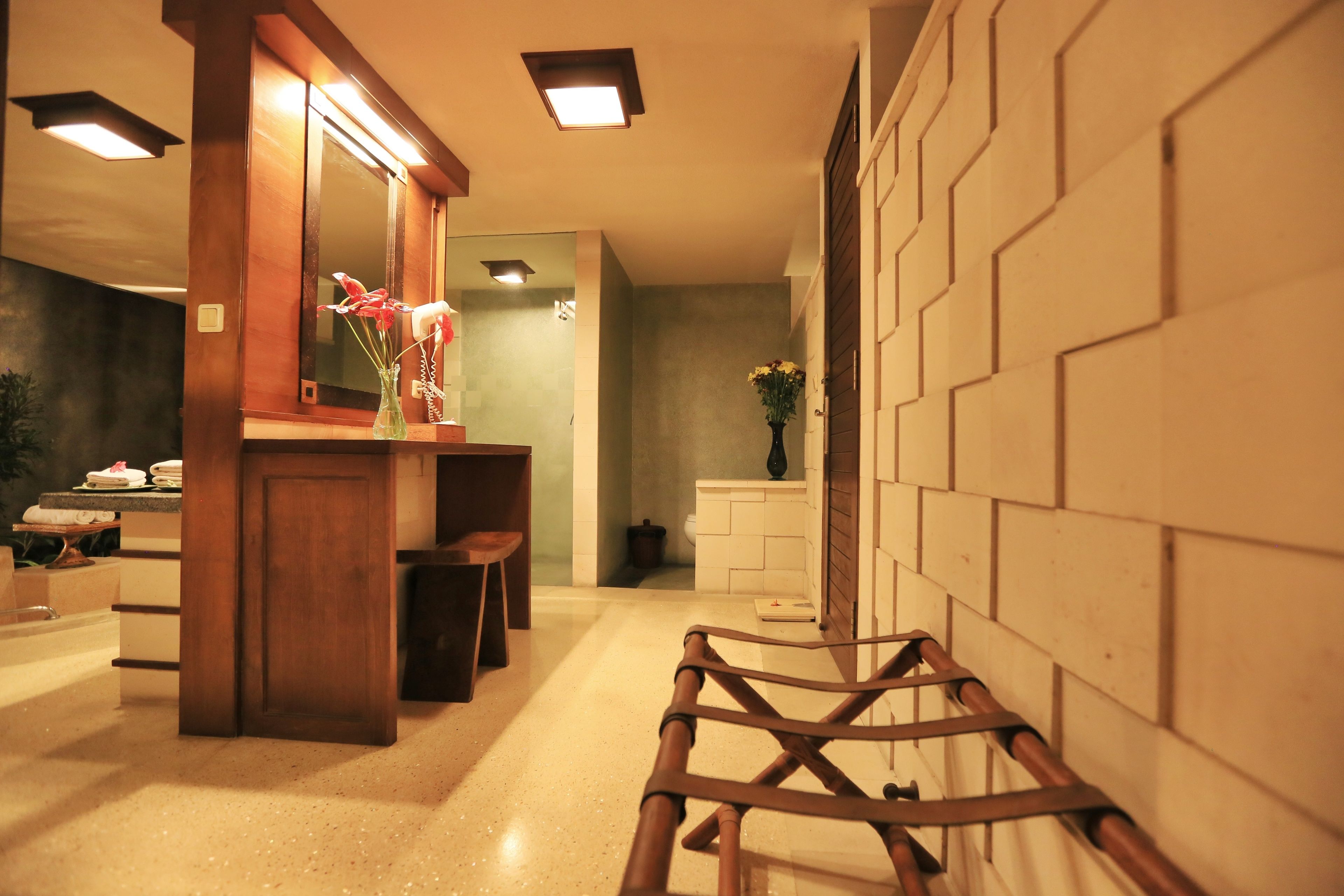 A modern bathroom with a wooden vanity, a mirror, and a bench.