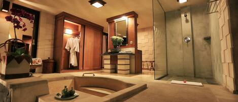 A modern bathroom with a bathtub, shower, and a vanity area.