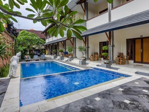 Una piscina al aire libre, tumbonas