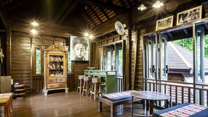 A wooden interior with a wooden cabinet, a table, and a bench. - Amata Lanna Chiang Mai One Member of The Secret Retreat (Chiang Mai)