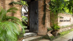 A traditional brick building with a dark wooden door, steps leading to a porch, and potted plants. - Amata Lanna Chiang Mai One Member of The Secret Retreat (Chiang Mai)