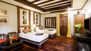A hotel room with two beds, wooden furniture, a TV, and framed pictures on the wall. - Amata Lanna Chiang Mai One Member of The Secret Retreat (Chiang Mai)
