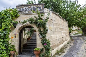 Un arco de piedra que conduce a un edificio con el letrero "ABRAS CAVE HOTEL".
