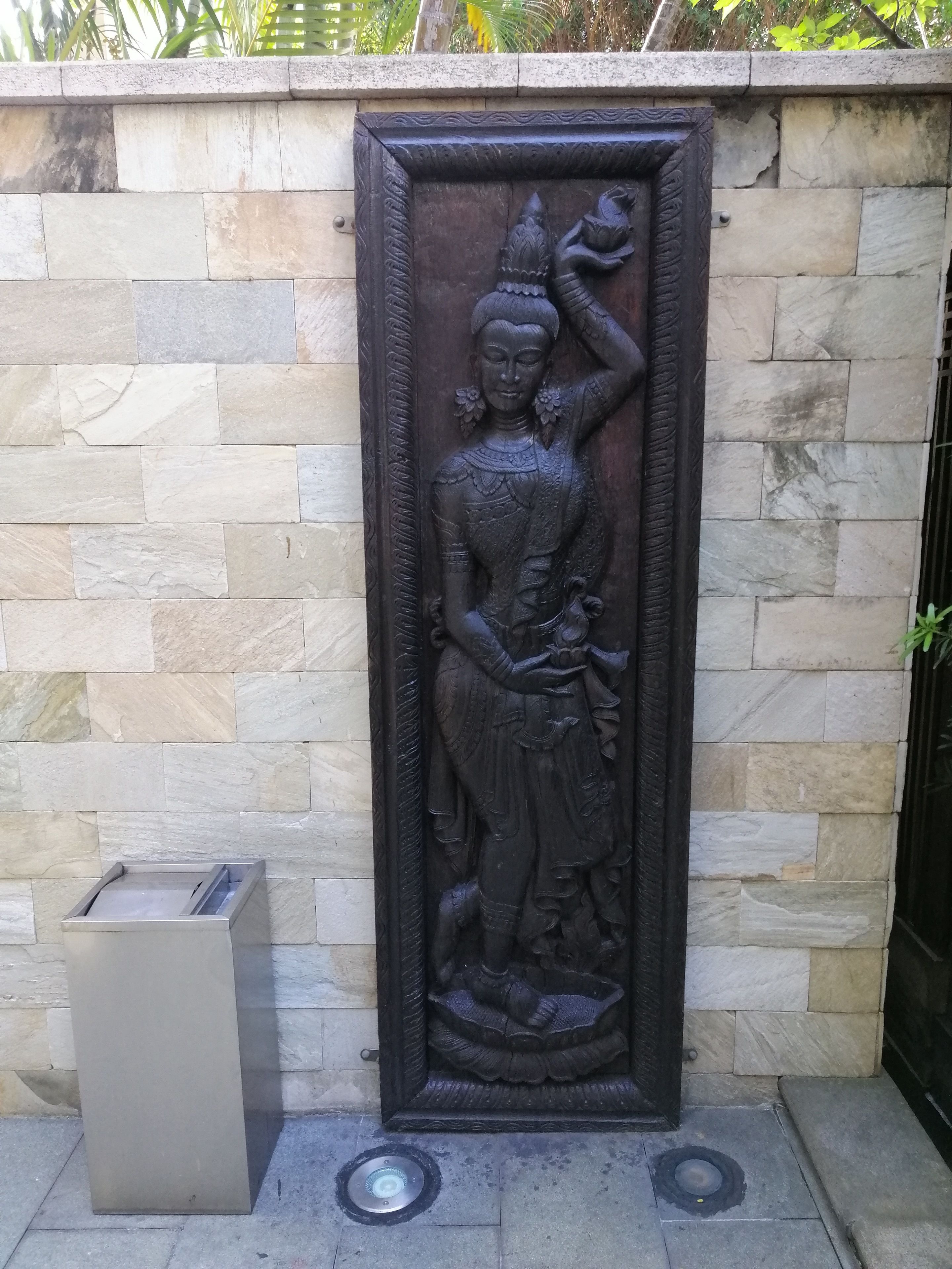 Un muro de piedra con un relieve de una figura sosteniendo a un niño.
