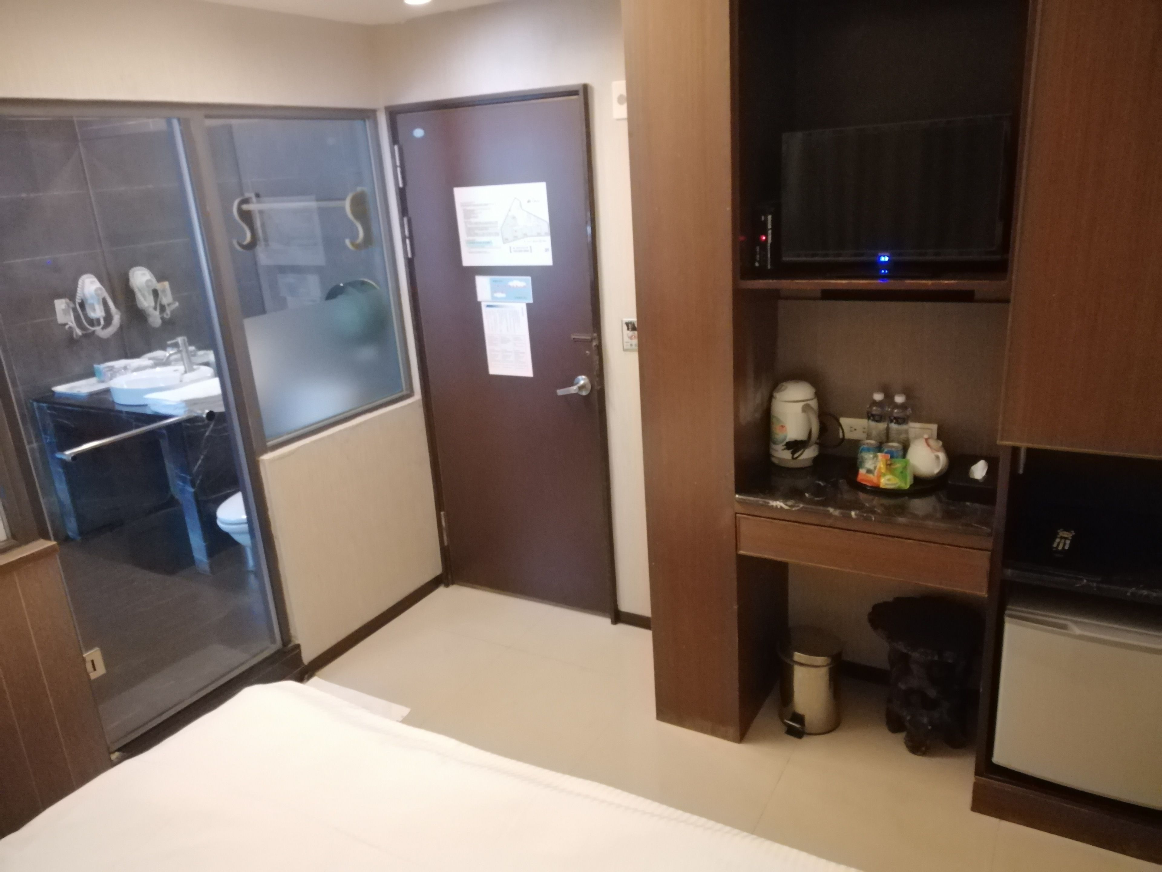 A compact hotel room with a kitchenette, a small dining area, and a separate bathroom.