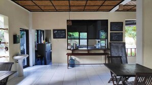 A cafe with a wooden ceiling, a water dispenser, and a menu board.