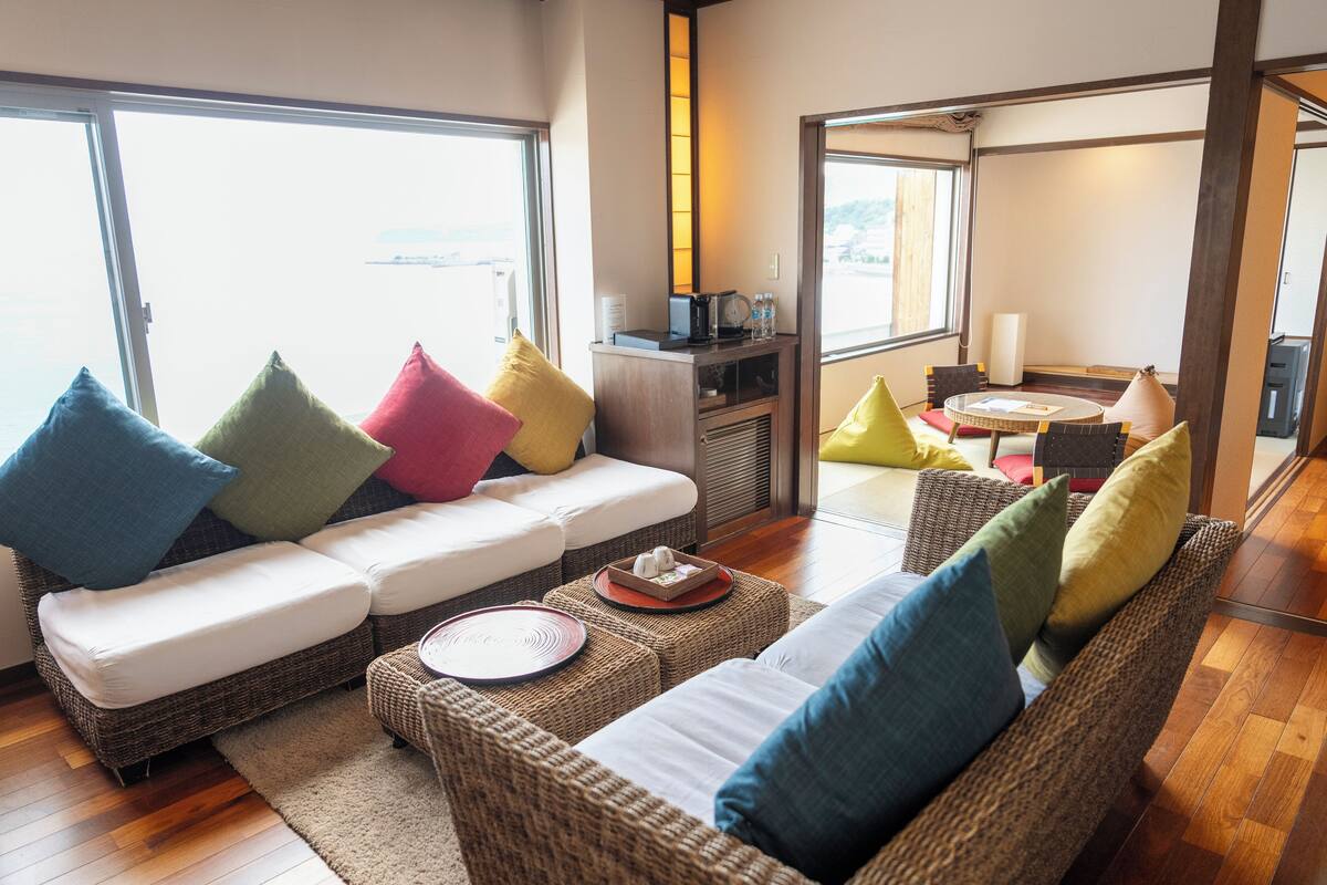A modern living room with a sofa, ottoman, and a small table with a tray.